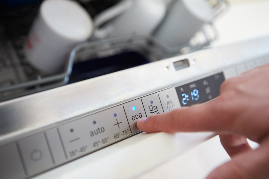 A person presses the eco setting on a dishwasher.