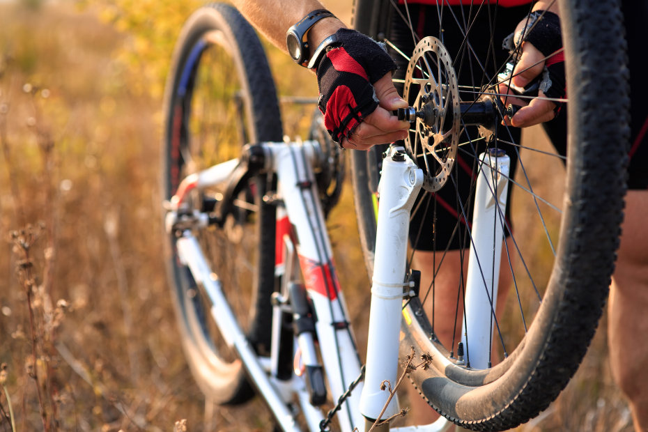 Cyclist puts front tire back on.