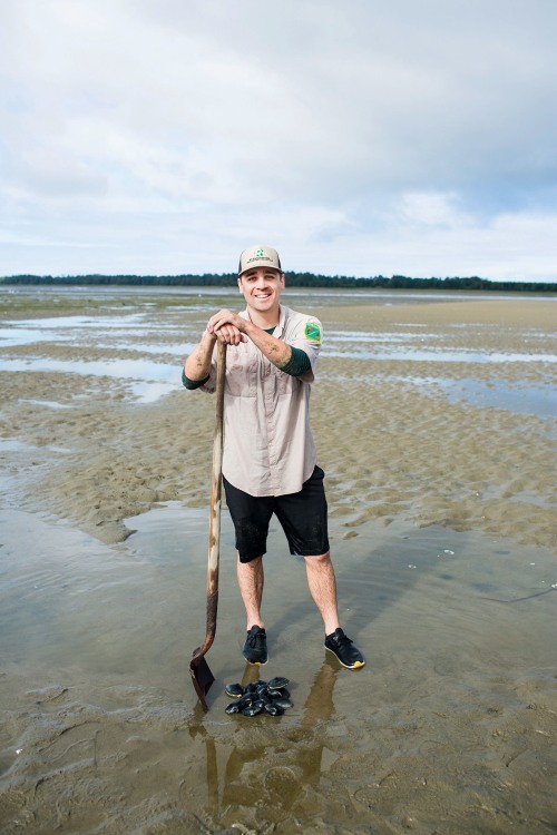 Jesse Kane proudly leans on shovel over a freshly dug pile of butter clams on the Oregon coast