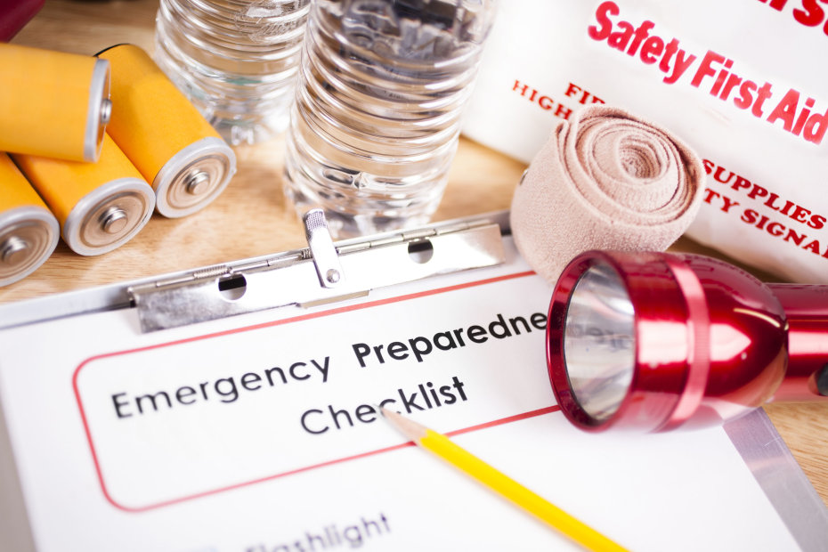 Emergency preparedness checklist surrounded by supplies.