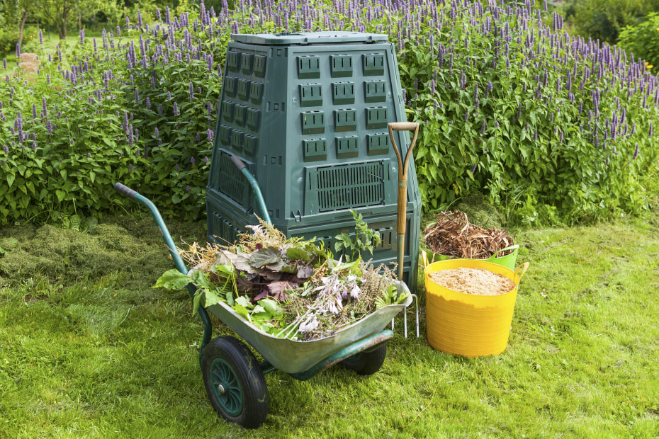 large backyard composter with mix of greens and browns.