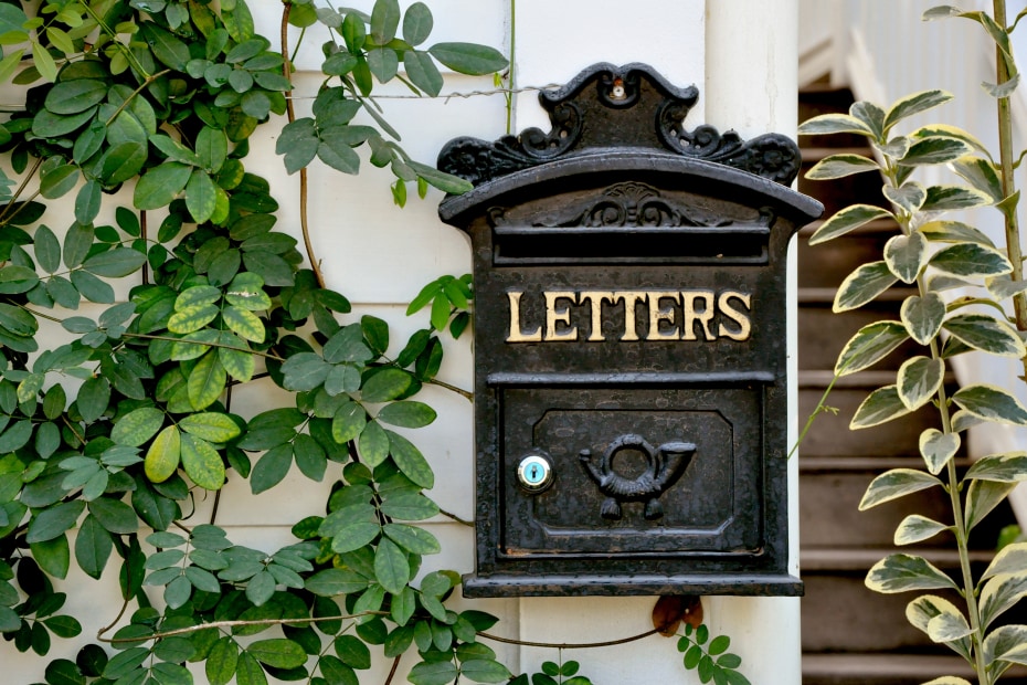 Antique letter box hanging on a white wall.