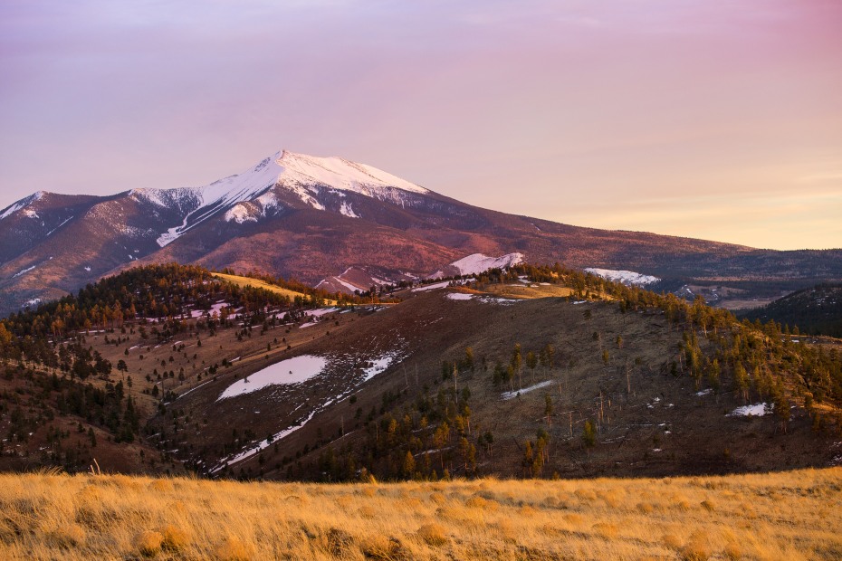 Sunset paints Humphreys Peak in shades of orange and purple.