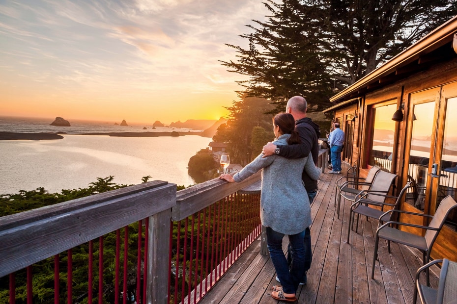 couple watching the sun set from River's End Restaurant & Inn in Jenner, California