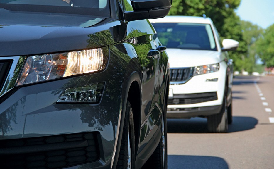 Light car following dark car in traffic