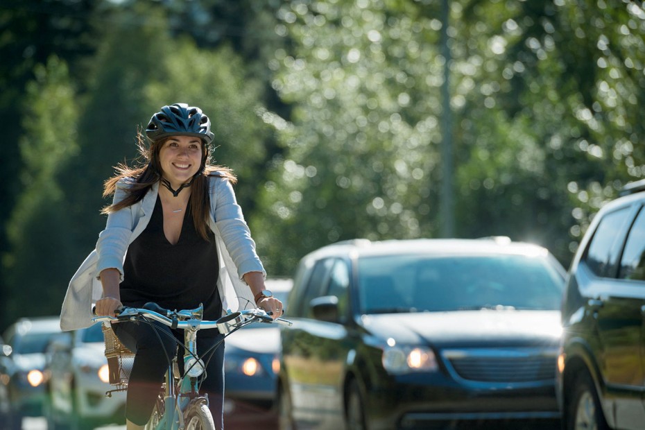 Cyclist in traffic wearing helmet and keeps to the right