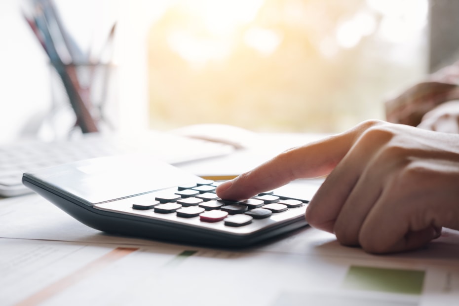 hand typing on calculator at desk