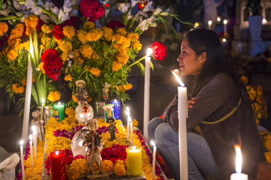 A woman at a decorated grave in Oaxaca, Mexico.