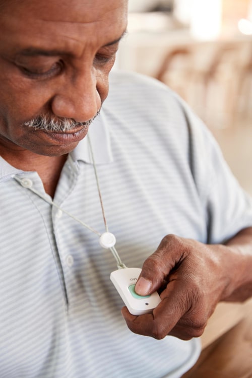 an older man uses a medical panic button necklace