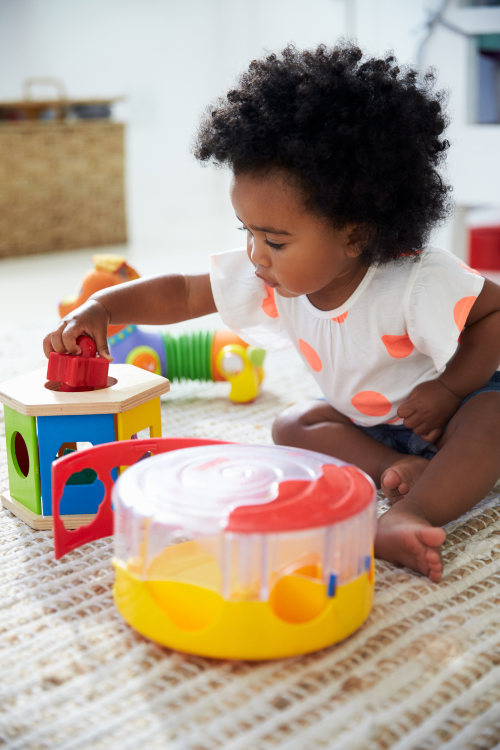 A young girl plays with toys in the playroom.