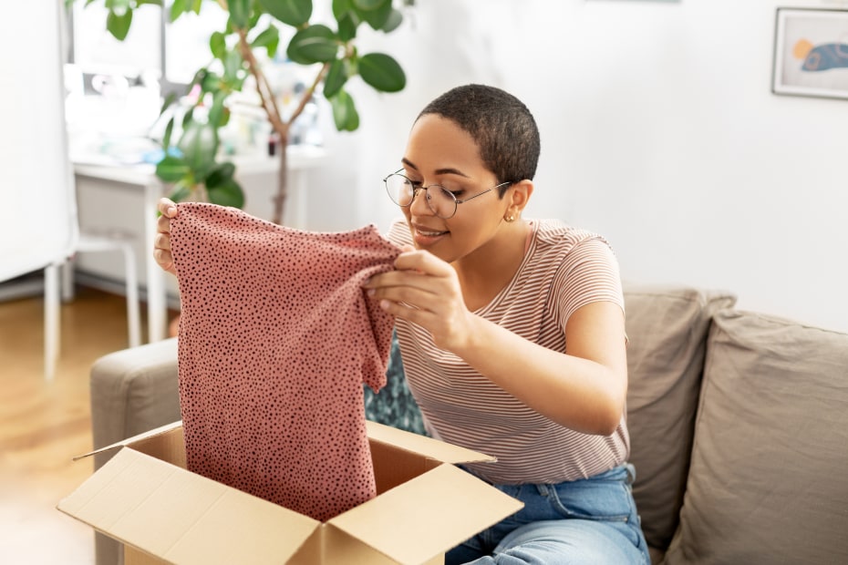 Woman packs a holiday gift before sending it in the mail.