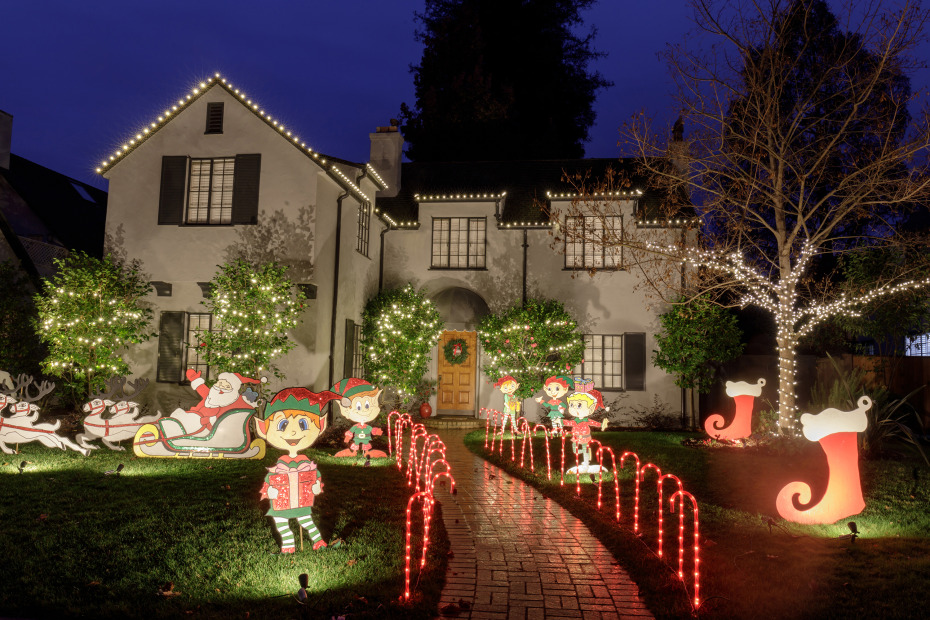 Bright elves glow in the front yard of a home on Palo Alto's Christmas Tree Lane.