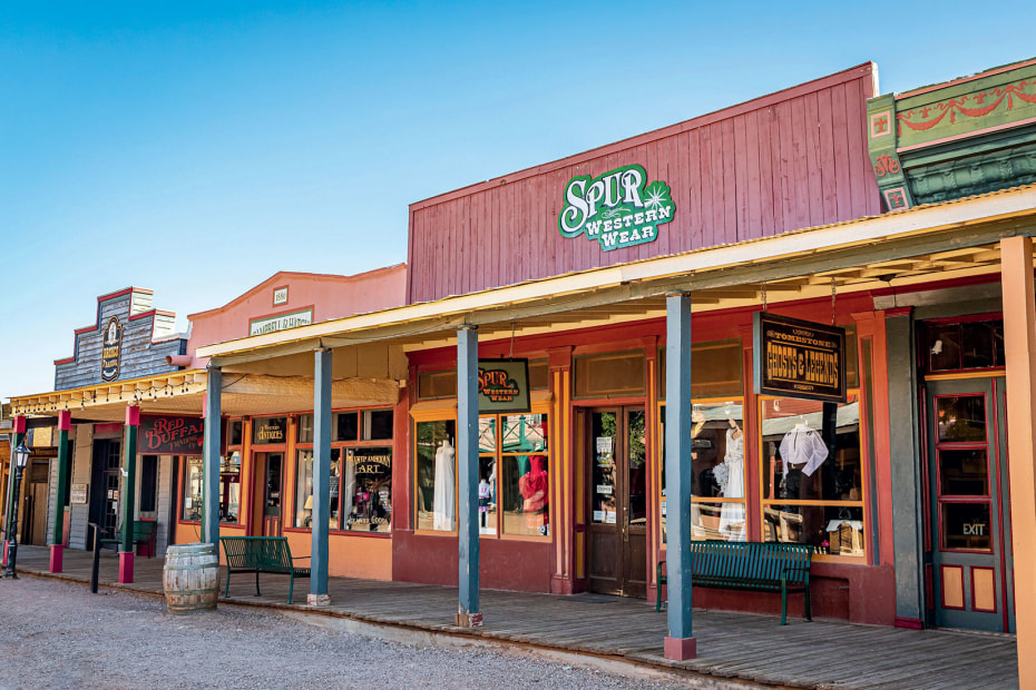 Old West style shops along Allen Street beckon from shaded wooden sidewalks in Tombstone, Arizona