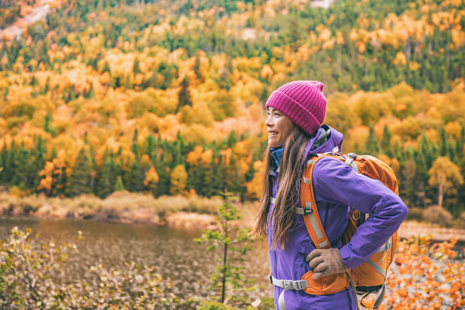A woman in a beanie and a warm coat on a hike.