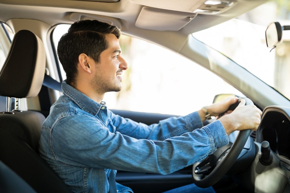 A man holding the steering wheel at 10 and 2 o'clock.