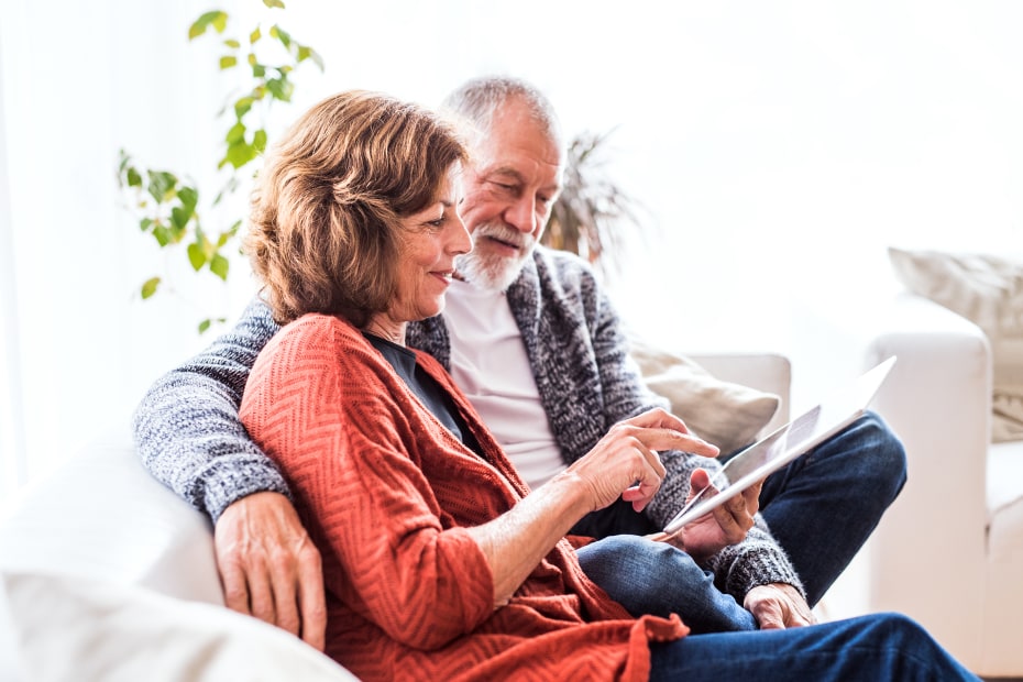 A senior couple do mental exercises on their tablet.