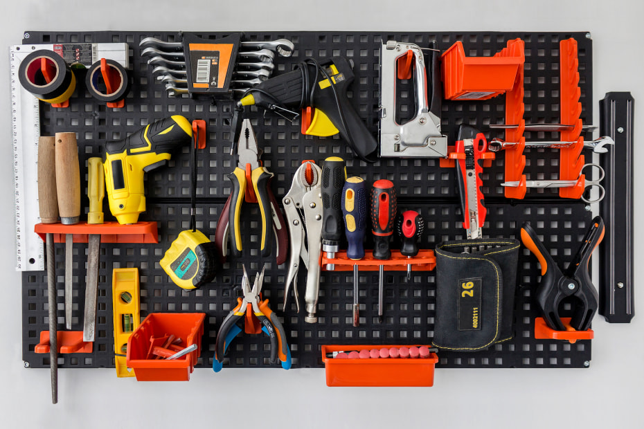 Tools neatly stored on a peg board in the garage.