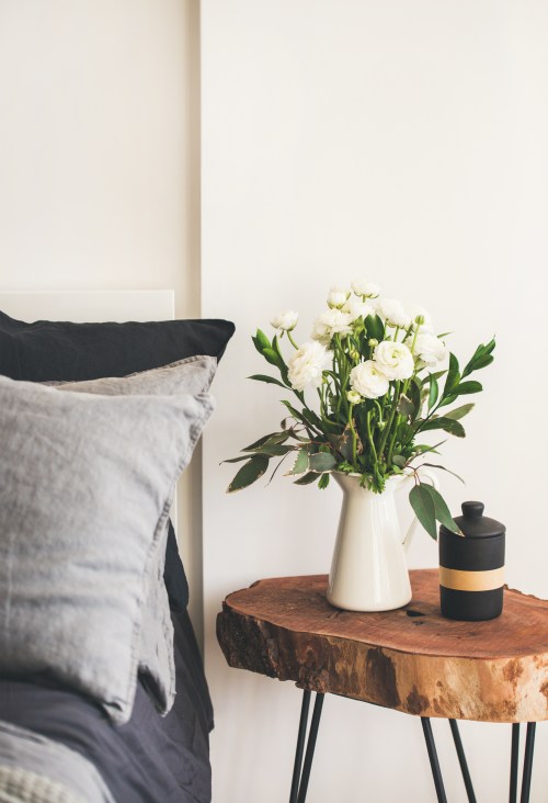 A Scandinavian styled bedroom with a live edge wood bedside table.