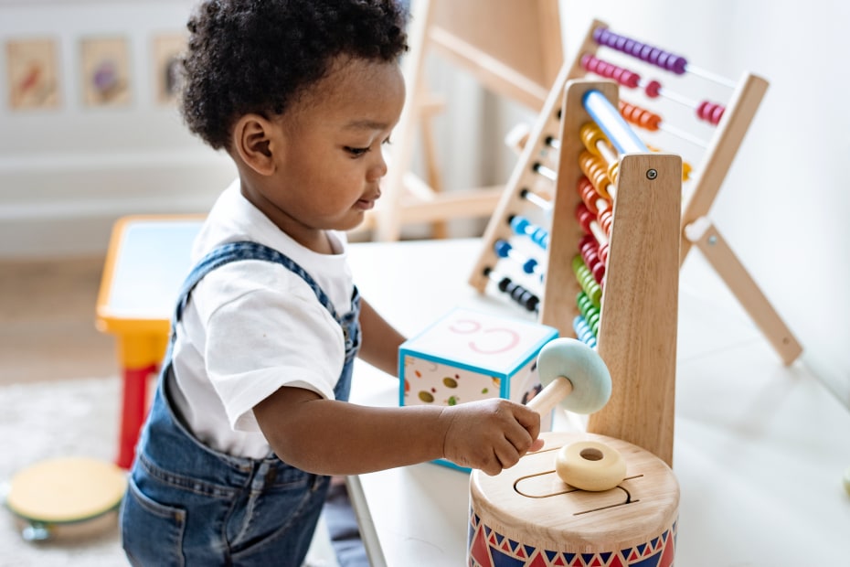 A toddler plays with colorful wooden toys.