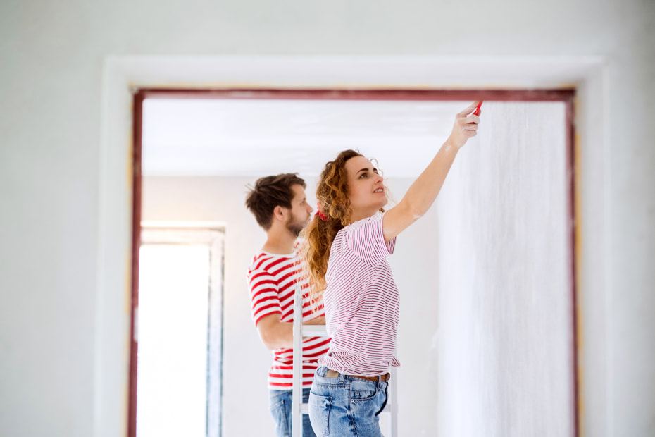 A couple paint their living room before listing their home.