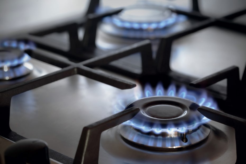 A gas stove with all of the burners on.