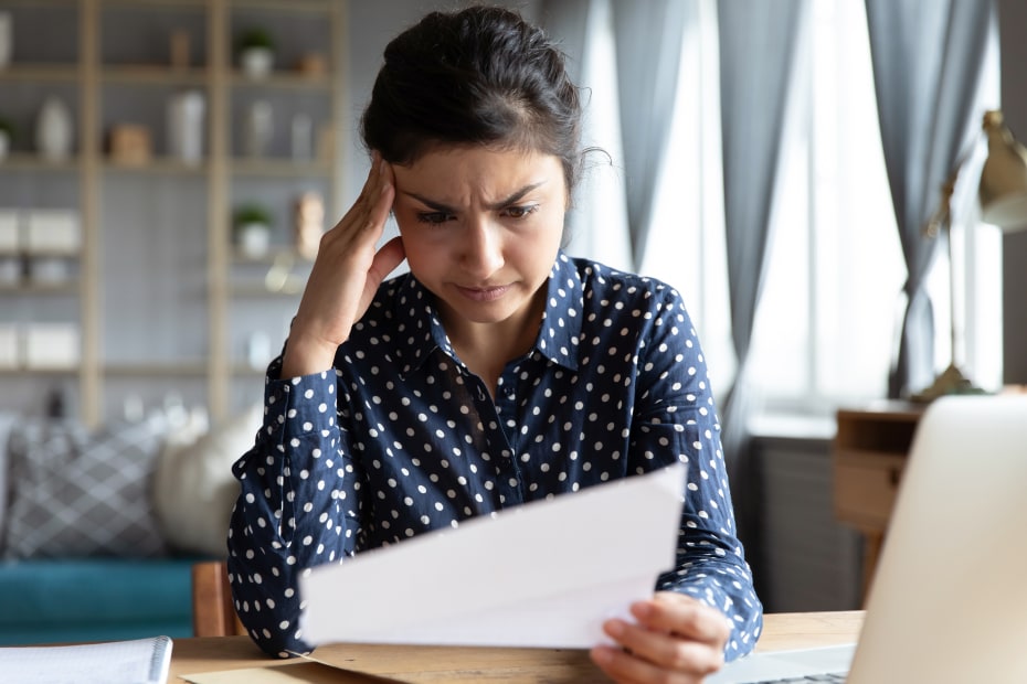 A woman frowns at a tax document.