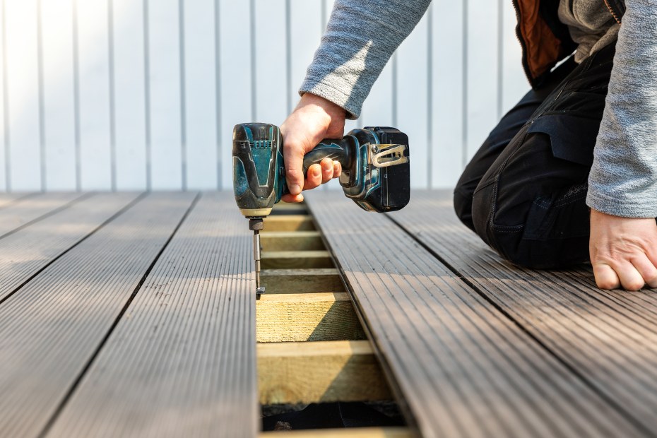 A homeowner installs a new piece of composite decking.