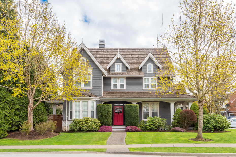 A large suburban home flanked by trees.