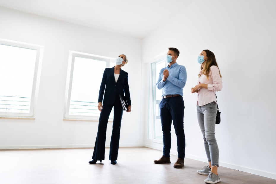 A couple and their real estate agent look for signs of water damage in a home.