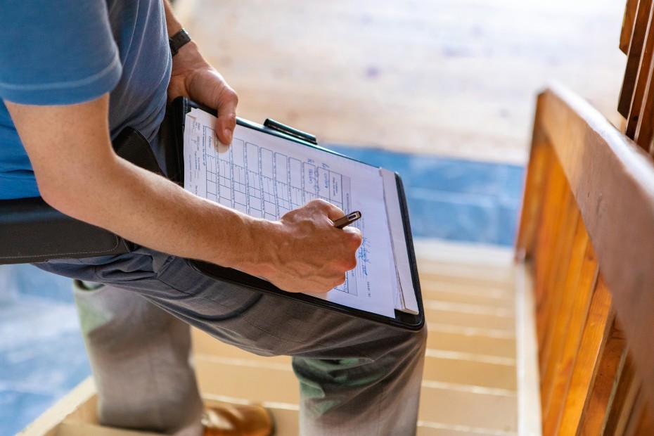 A home inspector takes notes on a property under contract.