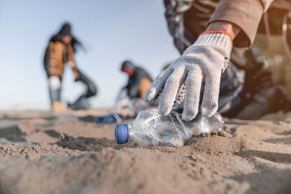 Volunteers clean up trash on the beach.