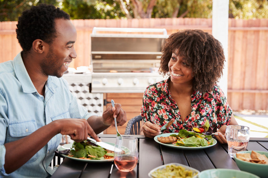 A couple eat barbecue outside.