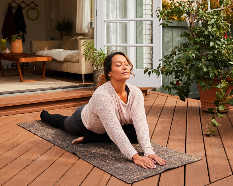A woman stretches out on her yoga deck.