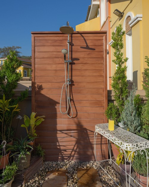 An outdoor shower with a wood back.
