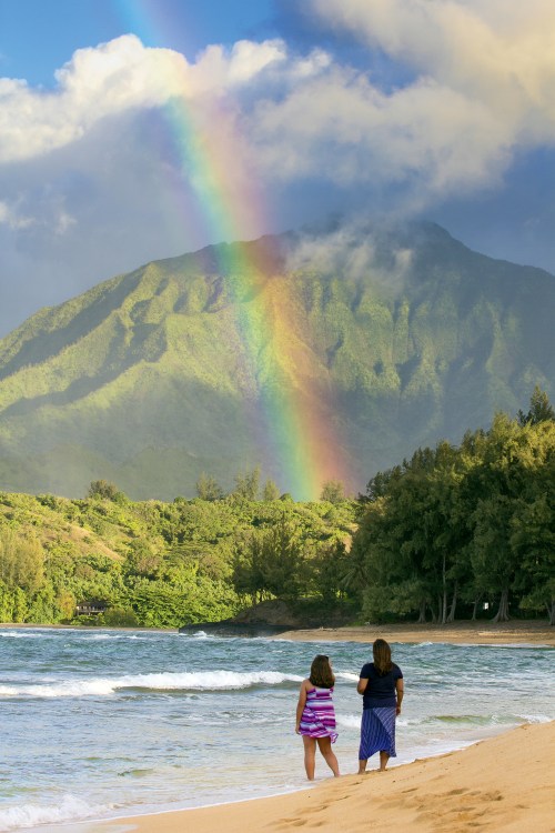 Two women look out on Haena on Kauai's north shore. 