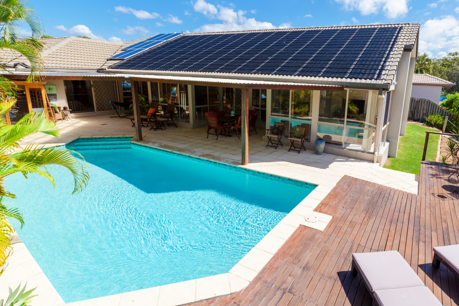 A solar-heated pool with the panels in the background.