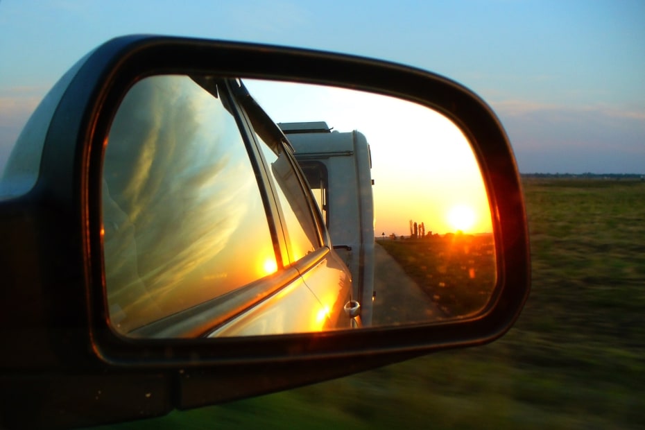 A the end of a trailer is reflected in a vehicle's side mirror.