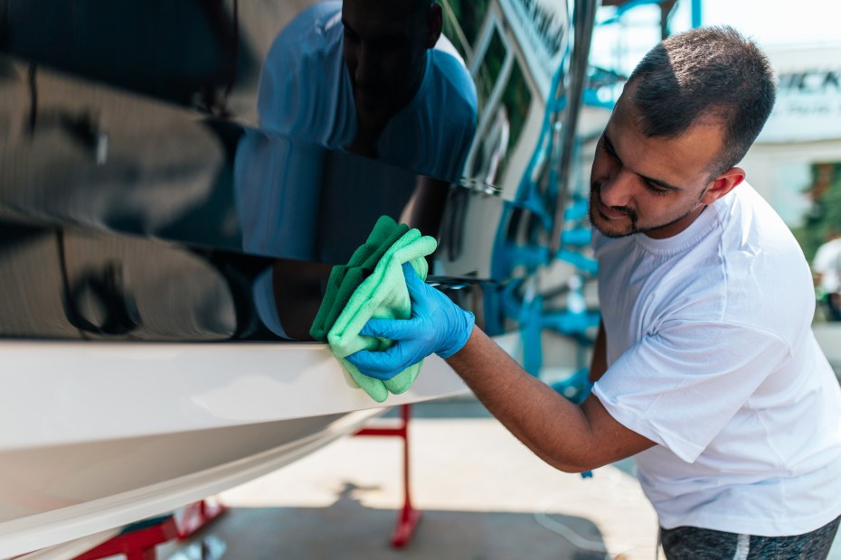 A man cleans a dry-docked boat.