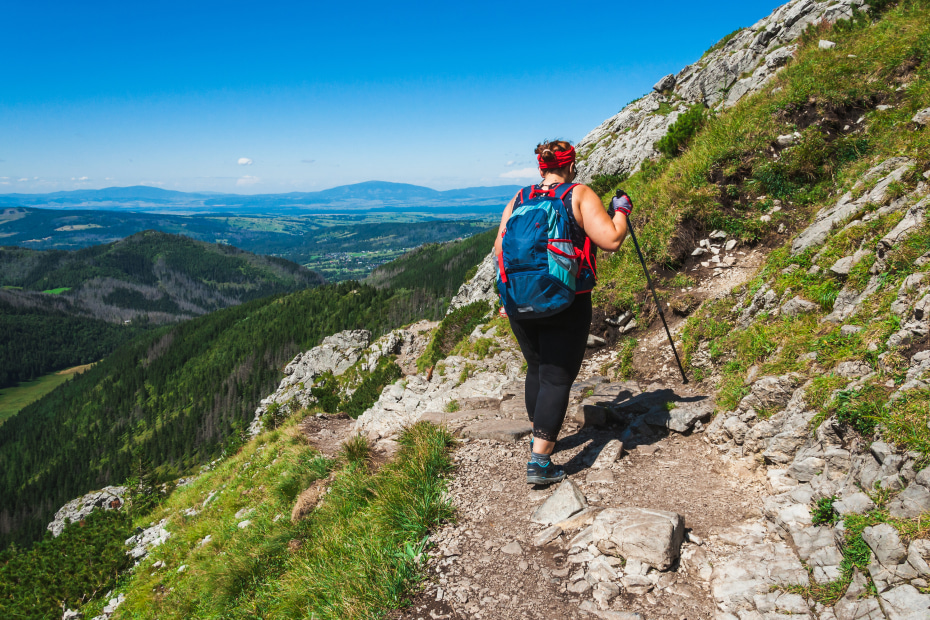 A woman hikes with hiking poles.