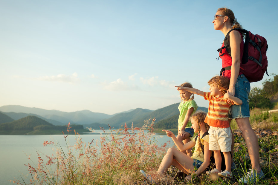 A mom and her three kids look out on a lake.