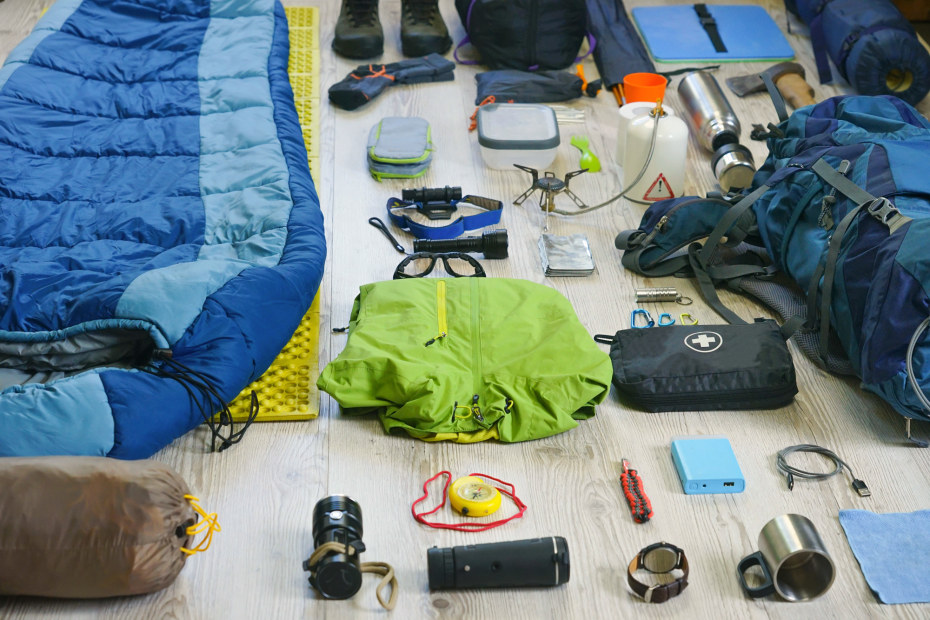 Camping gear layed out on a hardwood floor.