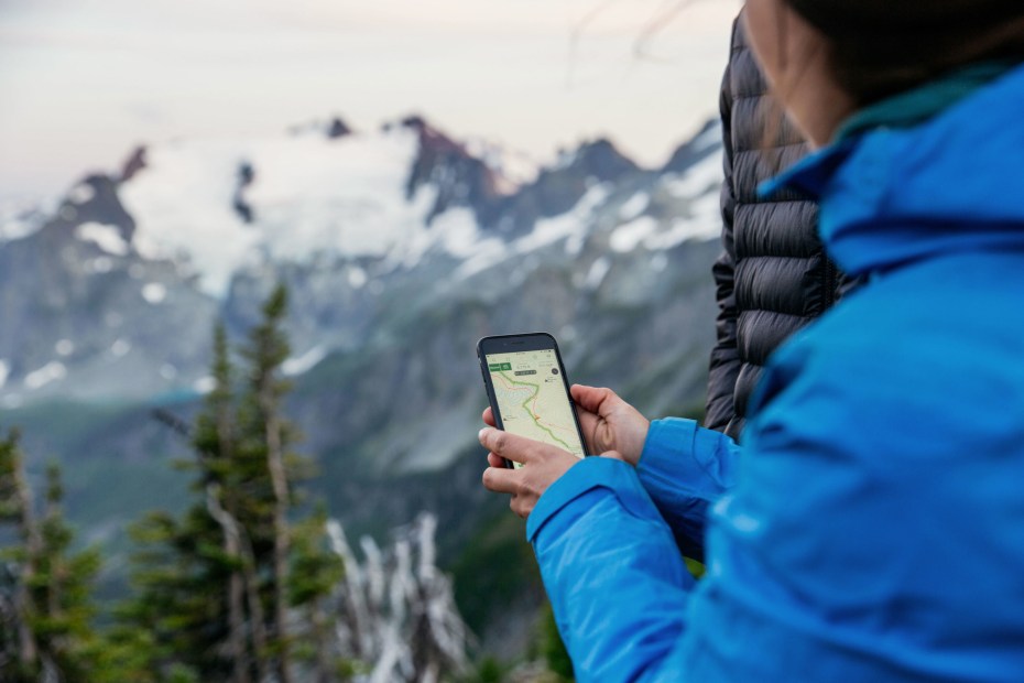 A woman uses Gaia GPS when hiking in the spring.