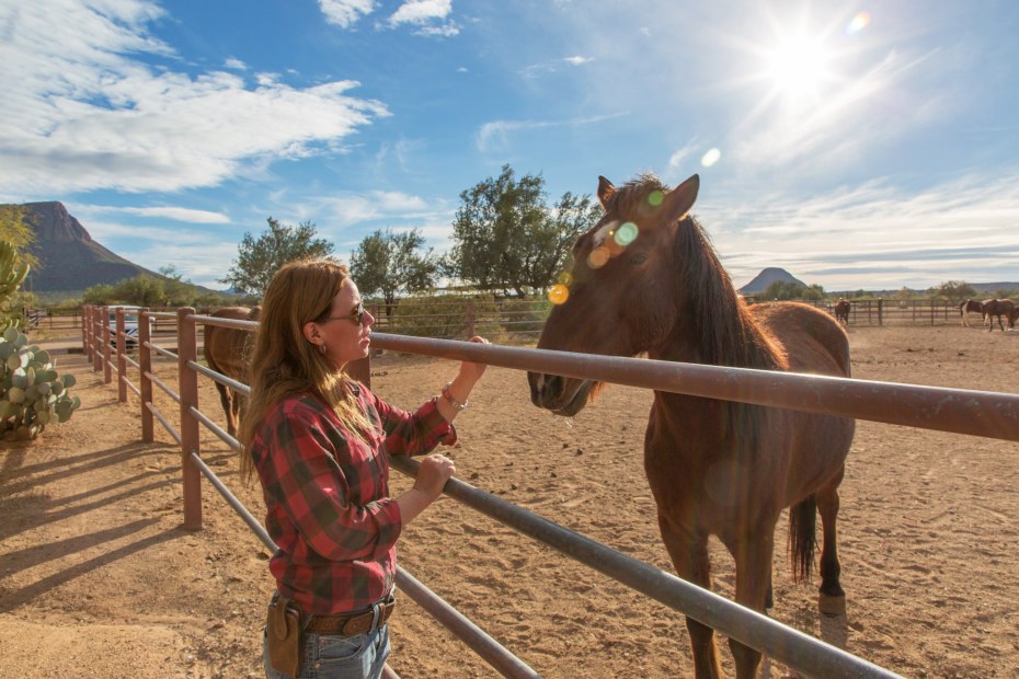 A woman pets a horse at White Stallion Ranch in Tucson, Arizona.