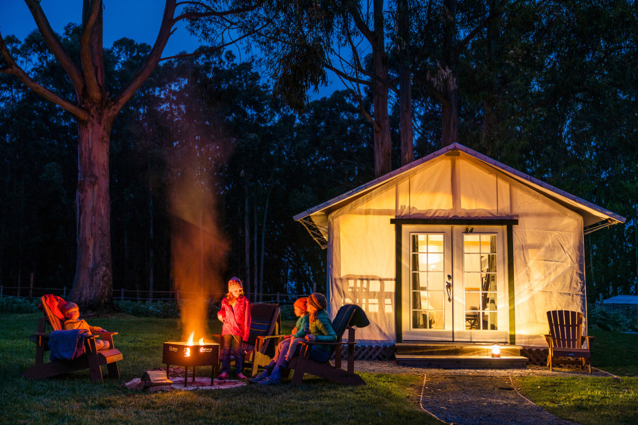 A family around the firepit at Costanoa's tent cabins.
