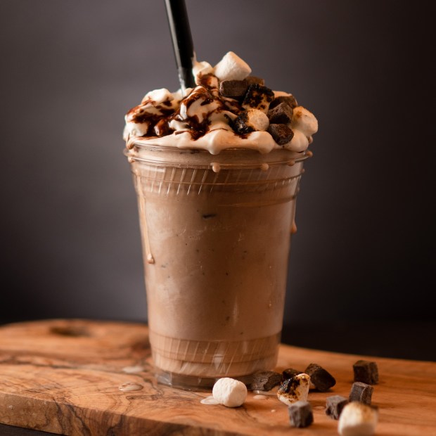 Chedda Burger campfire milkshake on a wood table.