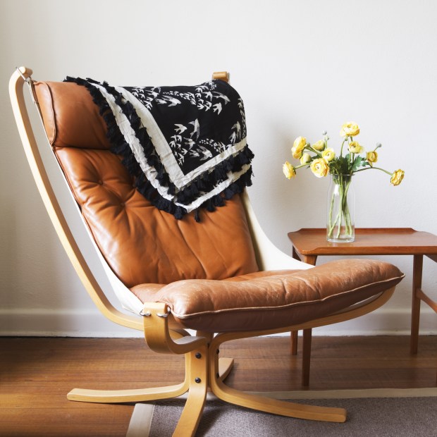Brown vintage retro tan leather danish chair in a modern living room.