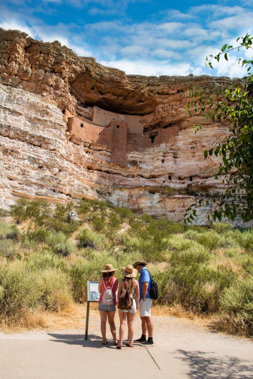 A family reads the interperative sign at Montezuma Castle National Monument dwellings in Camp Verde, Arizona.