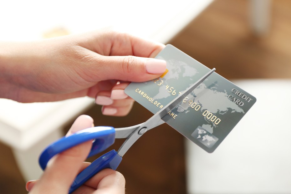 A woman cuts up a credit card.