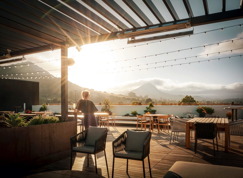 A woman watches the sunset on Hotel San Luis Obispo's rooftop bar.