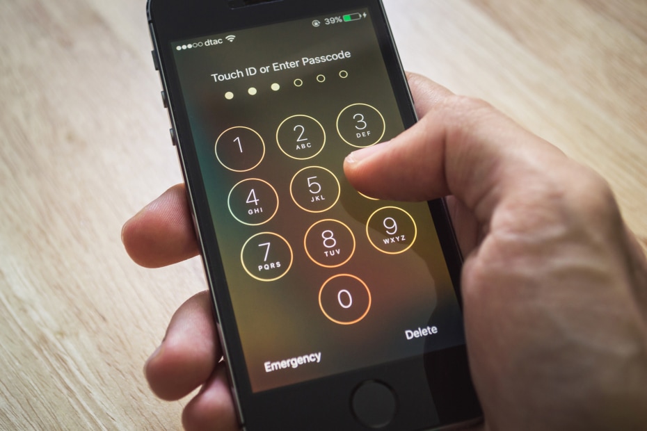 A person enters their passcode on a cellphone.